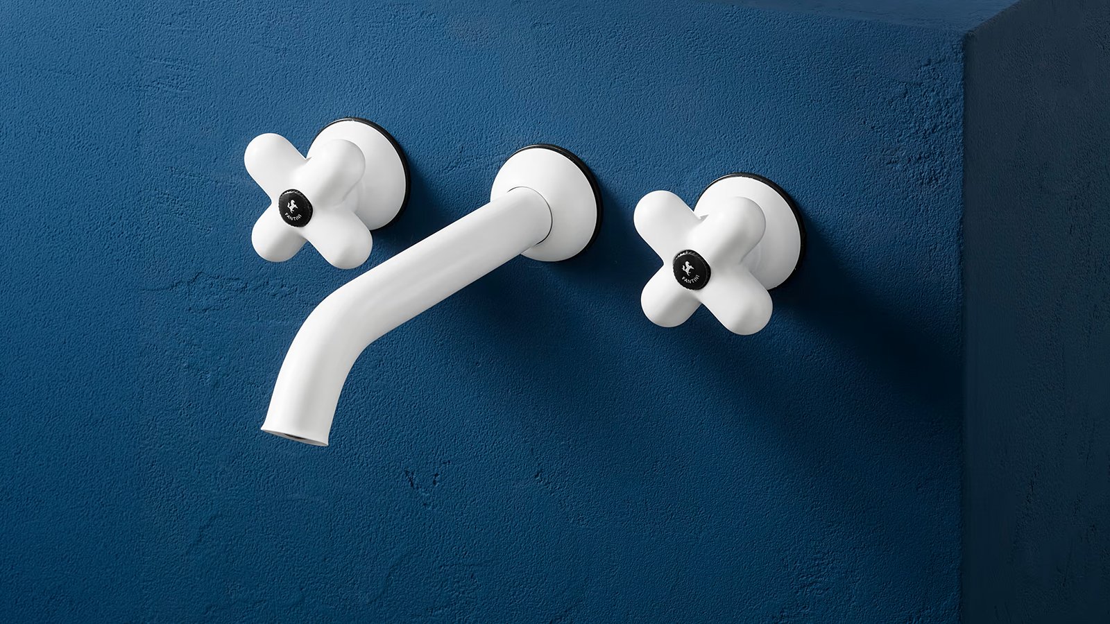 Grifería de diseño I Balocchi de Fantini: batería de tres agujeros en rojo y cromo sobre lavabo azul