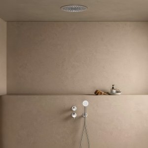 Junto a una bañera exenta, el mezclador de pie Flora de Fantini con teleducha