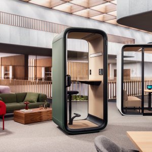 Framery One Compact entre mesas de una oficina abierta