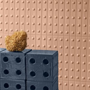 Pared revestida con listelos cerámicos Punto de Mutina, textura en relieve