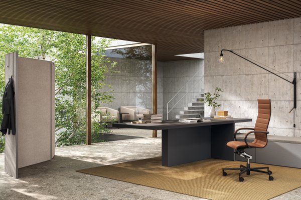 Escritorio ejecutivo Mux70 de Frezza con sillón de piel color cuero en una oficina de hormigón y madera